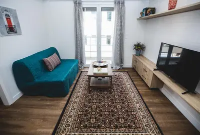 a living room with a blue couch and a tv at Ziva Apartment - 4th floor - Renovated 2019 in Athens