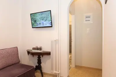 a living room with a couch and a television on the wall at Your address in Koukaki by Athenian Homes in Athens