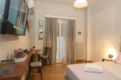 a bedroom with a bed and a desk with a television at Your address in Koukaki by Athenian Homes in Athens