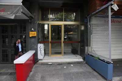 a man talking on a cell phone outside of a building at Your address in Koukaki by Athenian Homes in Athens