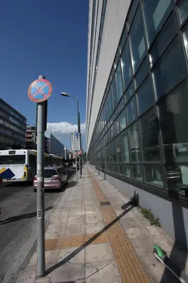 a sidewalk next to a building with a sign on it at Your address in Koukaki by Athenian Homes in Athens