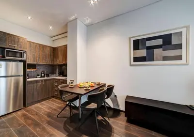 a kitchen with a table and chairs and a refrigerator at Classy and stylish apartment next to Hilton in Athens