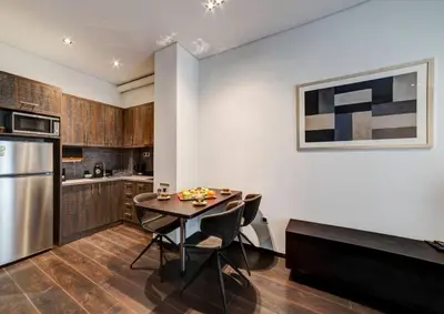 a kitchen with a table and chairs and a refrigerator at Classy and stylish apartment next to Hilton in Athens