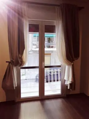 a sliding glass door with curtains and a window at Classy and stylish apartment next to Hilton in Athens