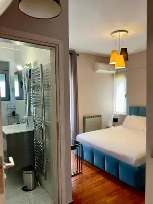 a bedroom with a bed and a bathroom with a sink at Brand new brilliant apartment at Athenian Riviera in Athens