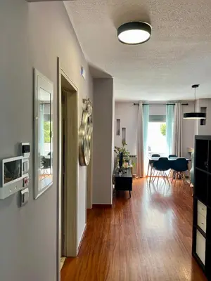 a living room with wooden floors and a dining room at Brand new brilliant apartment at Athenian Riviera in Athens
