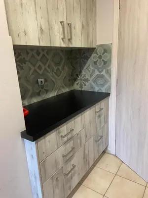 a kitchen with wooden cabinets and a black counter top at Brand new brilliant apartment at Athenian Riviera in Athens