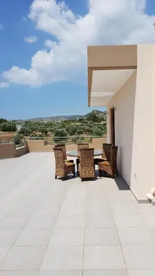 a patio with a table and chairs on a roof at Calmness Near the City in Metókhi