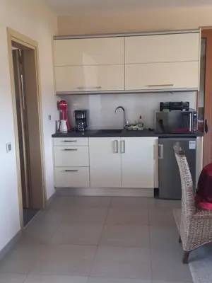 a kitchen with white cabinets and a red blender at Calmness Near the City in Metókhi