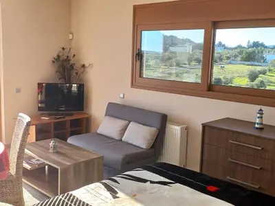 a living room with a couch and a tv at Calmness Near the City in Metókhi