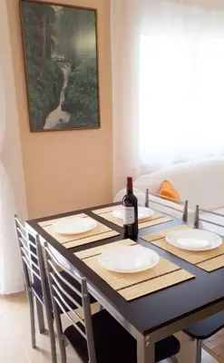 a dining room table with a bottle of wine on it at Stylish apartment near Katechaki in Athens