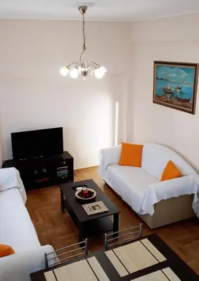 a living room with a white couch and a table at Stylish apartment near Katechaki in Athens