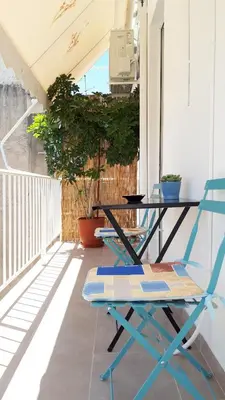 a table and a chair on a balcony at Stylish apartment near Katechaki in Athens