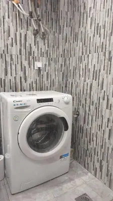 a washing machine in the corner of a bathroom at 133 Sokratous, Black marble. in Athens