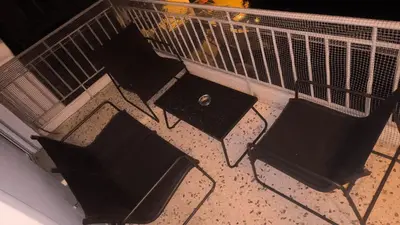 a group of chairs on a balcony at night at 133 Sokratous, Black marble. in Athens