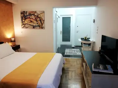 a bedroom with a bed and a desk with a television at Modern flat in city center in Athens