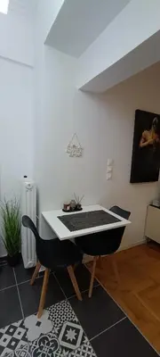 a table and a chair in a room at Modern flat in city center in Athens