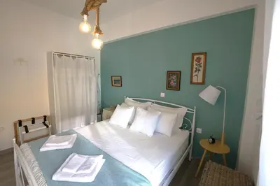 a bedroom with a bed with white sheets and blue walls at Central Apartment with Spacious Balcony in Athens