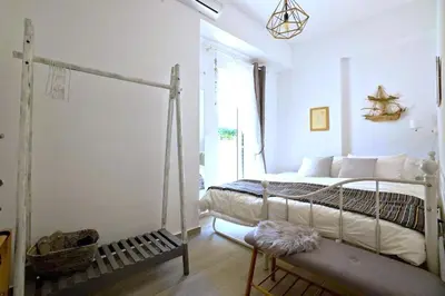 a white bedroom with a bed and a window at Central Apartment with Spacious Balcony in Athens
