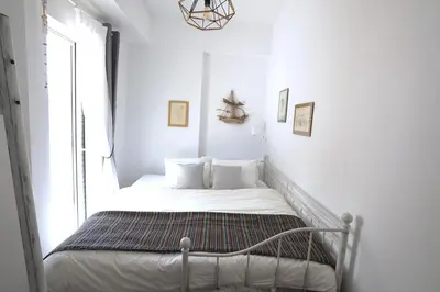 a small bed in a room with a window at Central Apartment with Spacious Balcony in Athens