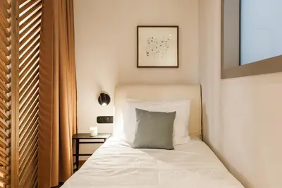 a bedroom with a white bed with a pillow at Modern Minimalist 3BD Apartment in Hilton District by UPSTREET in Athens