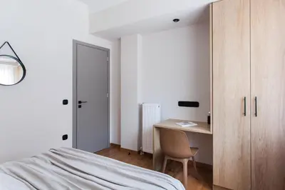a bedroom with a desk and a bed and a cabinet at Modern Minimalist 3BD Apartment in Hilton District by UPSTREET in Athens