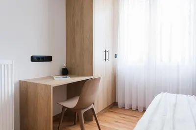 a bedroom with a desk and a chair next to a bed at Modern Minimalist 3BD Apartment in Hilton District by UPSTREET in Athens