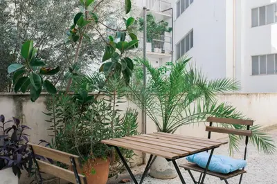 a patio with a wooden table and chairs and plants at Modern Minimalist 3BD Apartment in Hilton District by UPSTREET in Athens