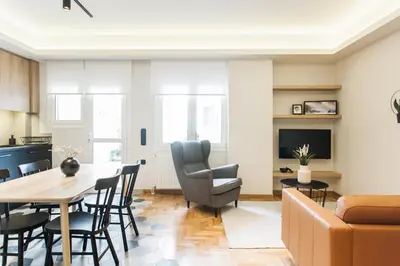 a living room with a table and chairs and a couch at Modern Minimalist 3BD Apartment in Hilton District by UPSTREET in Athens