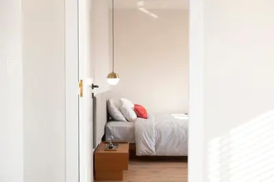 a bedroom with white walls and a bed with white sheets at Supreme Luxury Suites by Athens Stay in Athens