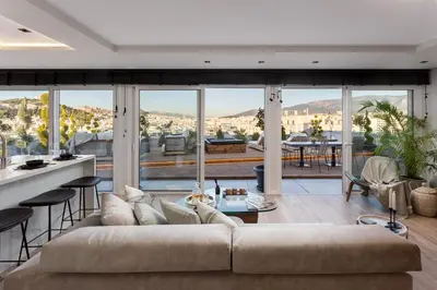 a living room with a large couch and a large window at Supreme Luxury Suites by Athens Stay in Athens