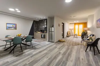 a living room with a table and chairs and a kitchen at Supreme Luxury Suites by Athens Stay in Athens
