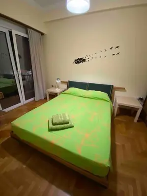 a bedroom with a bed with a green comforter at The House of Electra in Athens