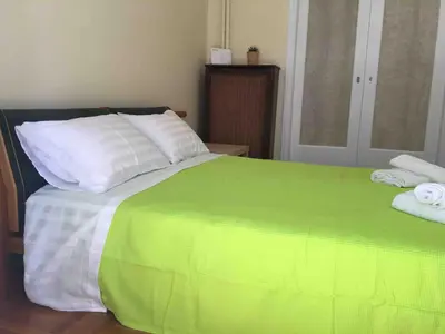 a green and white bed with two pillows on it at The House of Electra in Athens