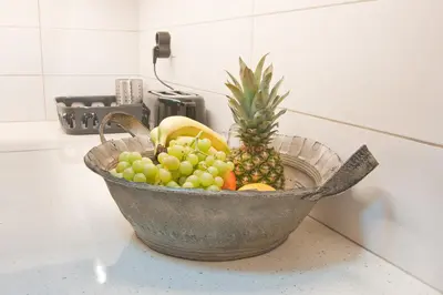 a metal bowl filled with fruit on a counter at Home pleasure project in Athens