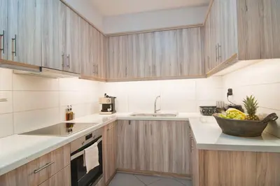 a kitchen with wooden cabinets and a bowl of fruit on the counter at Home pleasure project in Athens