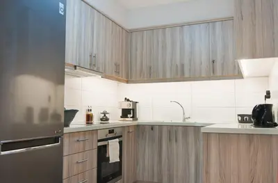 a kitchen with wooden cabinets and stainless steel appliances at Home pleasure project in Athens