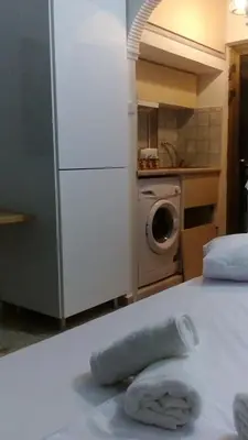 a towel on a bed in a kitchen with a refrigerator at agia marina riviera aigina in Agia Marina Aegina