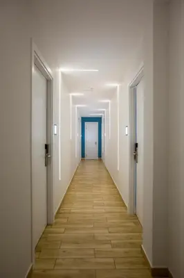 an empty corridor in an office building with a blue door at Athens Raise Acropolis Project in Athens