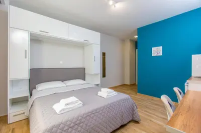 a bedroom with a bed and a blue wall at Athens Raise Acropolis Project in Athens