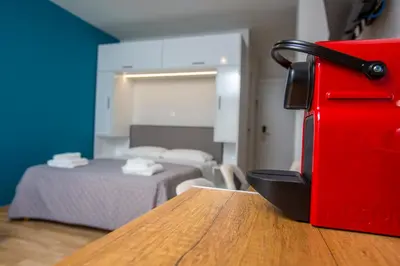 a red suitcase sitting on a table in a room with a bed at Athens Raise Acropolis Project in Athens