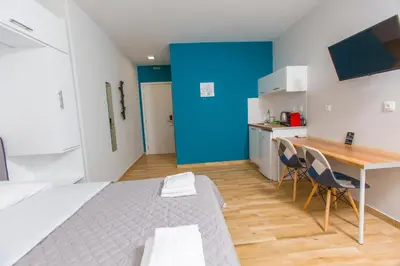 a room with a bed and a table and a blue wall at Athens Raise Acropolis Project in Athens