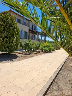 a walkway in front of a building with trees at MARFAIA - Villa by the sea in Áyioi