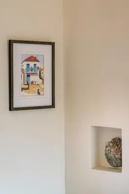 a picture hanging on a wall with a vase at MARFAIA - Villa by the sea in Áyioi