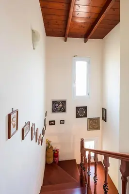 a staircase in a home with white walls and wooden ceilings at MARFAIA - Villa by the sea in Áyioi