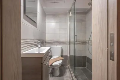 a bathroom with a toilet and a glass shower at Welcoming Koukaki Home by Cloudkeys in Athens