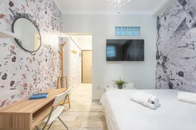 a bedroom with a bed and a desk and a tv at Welcoming Koukaki Home by Cloudkeys in Athens