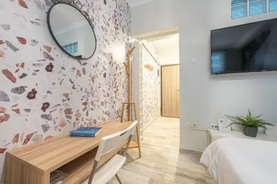 a bedroom with a desk and a mirror on a wall at Welcoming Koukaki Home by Cloudkeys in Athens