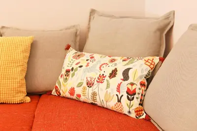 a pillow sitting on a couch with two pillows at Freshly Refurbished flat, in Central Koukaki in Athens