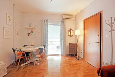 a dining room with a table and chairs and a door at Freshly Refurbished flat, in Central Koukaki in Athens
